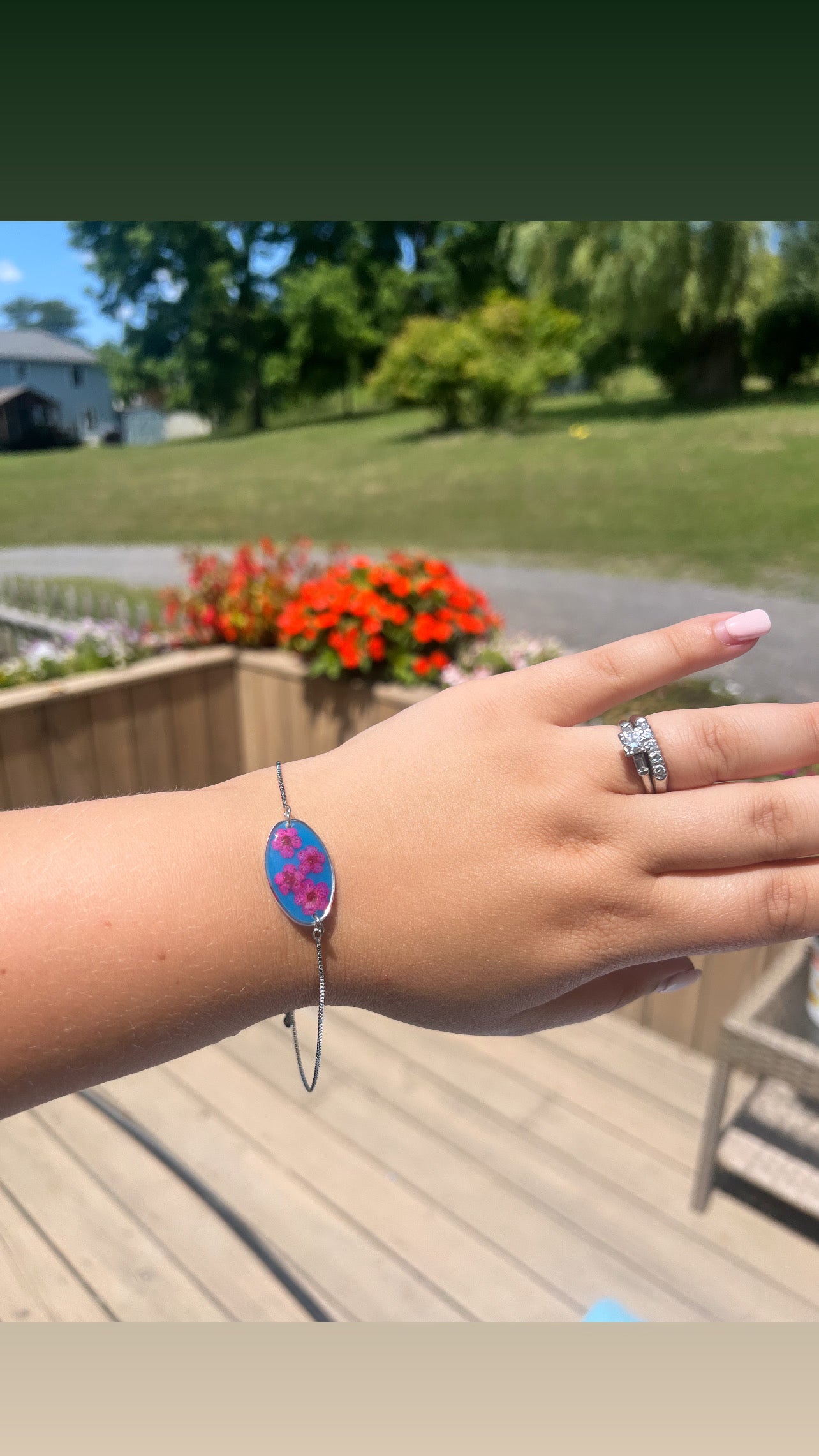 Bright blue with pink forget-me-not. Silver color adjustable bracelet.