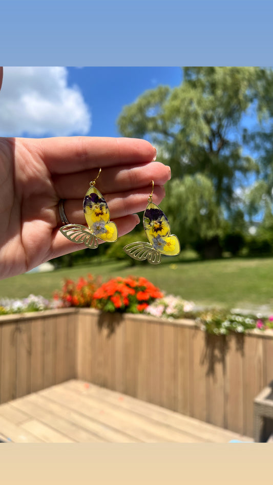 Butterfly dangles with pansies and forget me nots